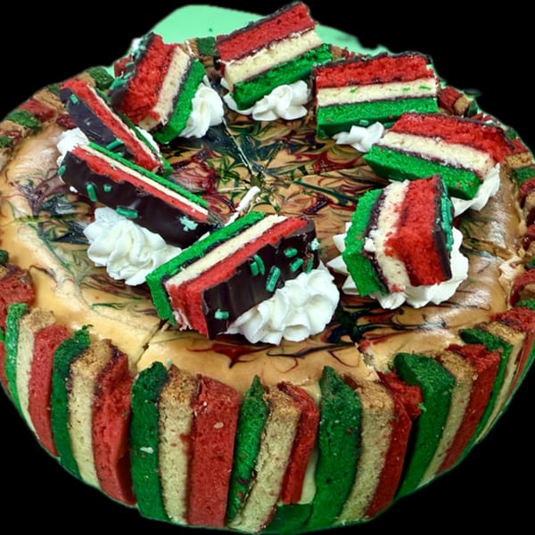 A cheesecake topped with Italian flag-colored rainbow cookie slices and whipped cream.