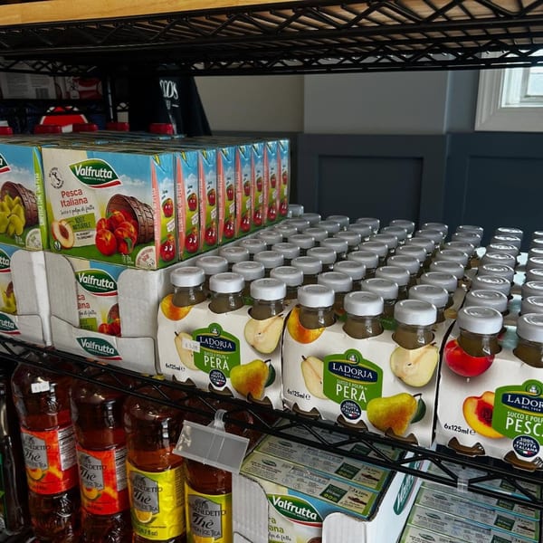 Shelves stocked with various fruit juices and iced teas, including peach and pear flavors.