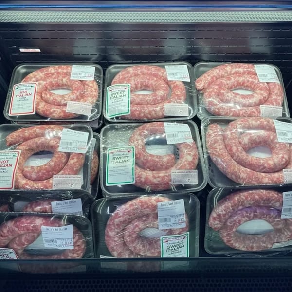 Packs of Rocco's Market & Deli's own hot and sweet Italian pork sausage in a refrigerated display.