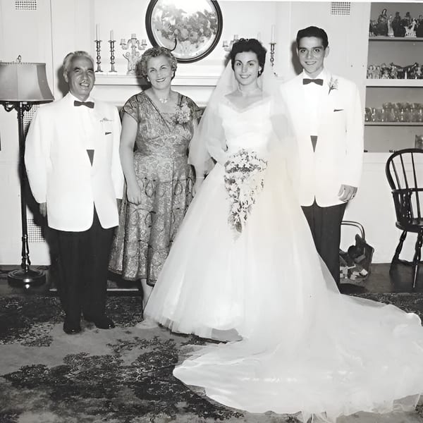 Black and white photo of a wedding party with a bride, groom, and two older adults.